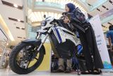 Mahasiswi Universtas Airlangga Eryza Fahilla Aswan (kanan) mencoba inovasi motor listrik Saga EV-OS di salah satu stan saat pembukaan pameran Start-Up & Innovation Expo (Sinox-01) di Surabaya, Jawa Timur, Rabu (20/11/2024). Pameran yang menampilkan karya-karya inovasi teknologi dan perusahaan rintisan (start-up) kolaborasi dua perguruan tinggi yaitu ITS serta Unair tersebut berlangsung hingga 23 November. ANTARA Jatim/Moch Asim.