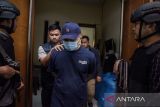 Anggota Kepolisian mengamankan terduga pelaku admin judi online saat penggerebekan markas judi online di Bandung, Jawa Barat, Kamis (21/11/2024). Polrestabes Bandung berhasil menggeledah dan mengamankan barang bukti komputer di sebuah ruangan yang memiliki 50 meja khusus admin yang dijadikan tempat untuk telemarketing judi online melalui server luar negeri dengan berkedok toko kain. ANTARA FOTO/Novrian Arbi/agr