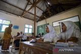 Sejumlah siswa kelas empat mengikuti kegiatan belajar mengajar di Madrasah Diniyah Tarbiyatul Athfal, Lebak, Banten, Kamis (21/11/2024). Guru di sekolah tersebut menyatakan, bangunan ruang kelas sudah rusak sejak 2019 pada plafon, atap, kursi, dan meja serta keterbatasan ruangan belajar sehingga para siswa harus belajar secara bergantian. ANTARA FOTO/Muhammad Bagus Khoirunas/gp