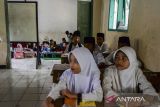 Sejumlah siswa kelas empat mengikuti kegiatan belajar mengajar di Madrasah Diniyah Tarbiyatul Athfal, Lebak, Banten, Kamis (21/11/2024). Guru di sekolah tersebut menyatakan, bangunan ruang kelas sudah rusak sejak 2019 pada plafon, atap, kursi, dan meja serta keterbatasan ruangan belajar sehingga para siswa harus belajar secara bergantian. ANTARA FOTO/Muhammad Bagus Khoirunas/gp