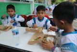 Sejumlah siswa menyantap  makan siang dengan menu ikan saat kegiatan makan bergizi gratis (MBG)  di Madrasyah Ibtidaiyah Negeri (MIN) 7, Banda Aceh, Aceh, Kamis (21/11/2024). Kegiatan makan bergizi gratis dengan menu ikan, daging, sayur dan buah di sekolah itu dalam rangka memperingati Hari Ikan Nasional  tahun 2024 dan  sekaligus  kampanye gemar makan ikan kepada siswa. ANTARA FOTO/Ampelsa.