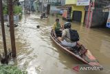 Warga menggunakan perahu untuk melintasi banjir di Dayeuhkolot, Kabupaten Bandung, Jawa Barat, Jumat (22/11/2024). BPBD Kabupaten Bandung mencatat sebanyak dua kecamatan di Kabupaten Bandung terdampak banjir setinggi 30cm hingga 110cm akibat meluapnya Sungai Citarum. ANTARA FOTO/Novrian Arbi/agr