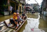 Warga menggunakan perahu untuk menuju rumah saat banjir melanda Kampung Bojongasih, Dayeuhkolot, Kabupaten Bandung, Jawa Barat, Minggu (24/11/2024). Menurut data dari petugas Desa Dayeuhkolot mencatat sebanyak 3.800 jiwa terdampak bencana banjir akibat luapan Sungai Citarum setinggi 50 hingga 150 cm. ANTARA FOTO/Raisan Al Farisi/agr
