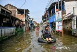 Warga menggunakan perahu untuk menuju rumahnya saat banjir melanda Kampung Bojongasih, Dayeuhkolot, Kabupaten Bandung, Jawa Barat, Minggu (24/11/2024). Menurut data dari petugas Desa Dayeuhkolot mencatat sebanyak 3.800 jiwa terdampak bencana banjir akibat luapan Sungai Citarum setinggi 50 hingga 150 cm. ANTARA FOTO/Raisan Al Farisi/agr
