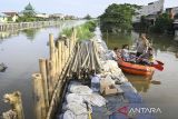 Kapolsek Jati Uwung Polres Metro Tangerang Kota, Kompol Robiin bersama warga meninjau turap yang jebol saat banjir merendam Perumahan Garden City Residence, Periuk, Kota Tangerang, Banten, Minggu (24/11/2024). Banjir merendam ratusan rumah warga sejak Sabtu (23/11/2024) malam yang disebabkan jebolnya turap kali sepanjang 10 meter karena tidak kuat menahan derasnya arus air kali saat curah hujan tinggi. ANTARA FOTO/Sulthony Hasanuddin/gp