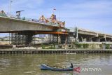 Nelayan melintas menggunakan perahu di dekat proyek pembangunan Jalan Tol Kamal-Teluknaga-Rajeg atau Tol PIK 2 di Kosambi, Kabupaten Tangerang, Banten, Minggu (24/11/2024). Jalan Tol yang menghubungkan Tol Sedyatmo dan kawasan Pantai Indah Kapuk (PIK) 2 sepanjang 38,60 kilometer dengan anggaran Rp23 triliun tersebut direncanakan beroperasi pada Kuartal I/2025. ANTARA FOTO/Sulthony Hasanuddin/gp