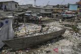 Warga berjalan di Kampung Dadap yang dipenuhi sampah di Kosambi, Kabupaten Tangerang, Banten, Minggu (24/11/2024). Sebagian warga di kampung tersebut masih membuang sampah rumah tangga sembarangan dan membutuhkan penerapan sistem pengelolaan sampah agar tidak menimbulkan penyakit di pemukiman tersebut. ANTARA FOTO/Sulthony Hasanuddin/gp