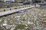 Warga melintasi jembatan Kali Dadap yang dipenuhi sampah di Kosambi, Kabupaten Tangerang, Banten, Minggu (24/11/2024). Kali tersebut dipenuhi sampah yang tersumbat sehingga menimbulkan bau tak sedap dan berpotensi menimbulkan penyakit bagi warga sekitar. ANTARA FOTO/ Sulthony Hasanuddin/gp