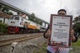 Anggota Railfans Cimahi menunjukkan poster keselamatan saat sosialisasi keselamatan perlintasan sebidang di Ngamprah, Kabupaten Bandung Barat, Jawa Barat, Minggu (24/11/2024). PT KAI Daop 2 Bandung bersama Railfans Cimahi dan relawan perlintasan menggelar sosialisasi keselamatan perlintasan sebidang yang bertujuan untuk meningkatkan kesadaran masyarakat akan pentingnya mentaati peraturan lalu lintas saat melintas di perlintasan sebidang kereta api demi keselamatan. ANTARA FOTO/Abdan Syakura/agr
