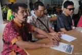 Penyandang tunanetra meraba surat suara yang dilengkapi huruf braille saat sosialisasi Pilkada 2024 kepada pemilih disabilitas di Denpasar, Bali, Minggu (24/11/2024). Kegiatan yang digelar KPU Bali tersebut untuk meningkatkan partisipasi pemilih penyandang disabilitas pada Pilkada Serentak 2024 yang berlangsung Rabu (27/11). ANTARA FOTO/Nyoman Hendra Wibowo/wsj.