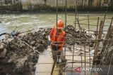 Sejumlah pekerja menyelesaikan proyek perbaikan tanggul Kali Ciputat di Perumahan Taman Mangu Indah, Pondok Aren, Tangerang Selataan, Banten, Senin (25/11/2024). Proyek pembangunan tanggul Kali Ciputat senilai Rp9 miliar tersebut terus dikebut agar tidak kembali jebol dan menyebabkan banjir di kawasan pemukiman saat terjadi hujan deras. ANTARA FOTO/Sulthony Hasanuddin/gp