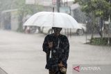 Warga mengenakan payung saat hujan di Jalan Raya Petir - Tunjung, Kabupaten Serang, Banten, Senin (25/11/2024). Badan Meteorologi Klimatologi dan Geofisika (BMKG) memperkirakan puncak musim hujan di Provinsi Banten terjadi pada bulan Januari - Februari 2025, sedangkan awal musim hujan mulai terjadi pada 10 hari terakhir bulan Desember 2024. ANTARA FOTO/Putra M. Akbar/gp