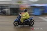 Pengendara motor mengenakan jas hujan saat melintas di Jalan Raya Petir - Tunjung, Kabupaten Serang, Banten, Senin (25/11/2024). Badan Meteorologi Klimatologi dan Geofisika (BMKG) memperkirakan puncak musim hujan di Provinsi Banten terjadi pada bulan Januari - Februari 2025, sedangkan awal musim hujan mulai terjadi pada 10 hari terakhir bulan Desember 2024. ANTARA FOTO/Putra M. Akbar/gp