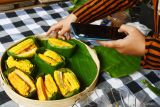 Seorang pedagang makanan melakukan siaran langsung melalui medsos menggunakan smartphone untuk menawarkan barang dagangannya di Pasar Pundensari Desa Wisata Gunungsari Kabupaten Madiun, Jawa Timur, Minggu (24/11/2024). Desa Wisata Gunungsari meraih juara pertama kategori digital dalam Anugerah Desa Wisata Indonesia (ADWI) 2024 dari Kementerian Pariwisata. Antara Jatim/Siswowidodo/mas.