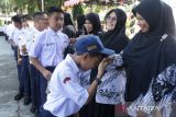 Sejumlah murid memberikan ucapan selamat kepada gurunya  seusai  upacara peringatan Hari Guru Nasional ke 79 tahun 2024 di SMP 1 Banda Aceh, Aceh, Senin (25/11/2024). Peringatan Hari Guru Nasional dengan tema 