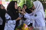 Seorang murid menyuapkan tumpeng kepada gurunya saat  upacara peringatan Hari Guru Nasional ke 79 tahun 2024 di SMP 1 Banda Aceh, Senin (25/11/2024). Peringatan Hari Guru Nasional dengan tema 