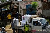 Petugas menurunkan logistik Pilkada dari atas mobil setibanya di TPS 06, Dayeuhkolot, Kabupaten Bandung, Jawa Barat, Selasa (26/11/2024). KPU Kabupaten Bandung mulai mendistribukan logistik untuk kebutuhan Pilkada Calon Bupati, Wakil Bupati Kabupaten Bandung, dan Calon Gubernur dan Wakil Gubernur Jawa Barat ke seluruh TPS yang ada di Kabupaten Bandung. ANTARA FOTO/Raisan Al Farisi/agr