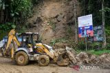 Warga melihat truk yang terhempas material tanah longsor di kawasan tikungan PDAM Tirtanadi, Sibolangit, Deli Serdang, Sumatera Utara, Rabu (27/11/2024). Bencana tanah longsor yang terjadi pada Selasa (26/11) malam tersebut mengakibatkan 25 warga luka-luka, dan empat warga dinyatakan meninggal dunia serta jalur utama Medan-Berastagi dan sebaliknya lumpuh total. ANTARA FOTO/Fransisco Carolio/