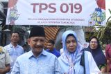 Calon petahana Bupati Situbondo Karna Suswandi (kiri) didampingi Istri Juma'ati (kanan) setelah melakukan pencoblosan di TPS 19, Kelurahan Dawuhan, Situbondo, Jawa Timur, Rabu (27/11/2024). Calon bupati Situbondo petahana yang telah ditetapkan sebagai tersangka oleh KPK terkait dalam dugaan kasus dana Pemulihan Ekonomi Nasional (PEN), Pengadaan Barang dan Jasa 2021-2024 tersebut memberikan hak suaranya dalam Pilbup Situbondo. Antara Jatim/Seno/mas.