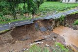 Foto udara jalan penghubung antar dusun yang ambles akibat banjir di Desa Rejoyoso, Kecamatan Bantur, Kabupaten Malang, Jawa Timur, Jumat (29/11/2024). Berdasarkan hasil identifikasi sementara Badan Penanggulangan Bencana Daerah (BPBD) Kabupaten Malang, enam titik banjir dan empat titik tanah longsor yang tersebar di enam kecamatan pada Kamis (28/11) tersebut menyebabkan 82 KK atau 283 Jiwa terdampak juga delapan rumah dan tiga jembatan rusak. Antara Jatim/Irfan Sumanjaya/um