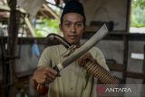 Perajin menunjukkan golok yang telah selesai dibuat di Desa Seuat Jaya, Petir, Kabupaten Serang, Banten, Jumat (29/11/2024). Kerajinan golok khas Banten tersebut  dijual dengan harga Rp 80 ribu - Rp 4,5 juta dan telah diekspor hingga ke Malaysia dan Pakistan melalui pemasaran secara daring. ANTARA FOTO/Putra M. Akbar/gp