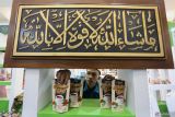 Pekerja menata produk minuman tradisional wedang uwuh dari Koppontren Delingsongo, Bojonegoro  di salah satu stan pameran saat pembukaan One Pesantren One Product (OPOP) Expo di Surabaya, Jawa Timur, Jumat (29/11/2024). Pameran yang berlangsung hingga 1 Desember tersebut menampilkan produk-produk unggulan dari berbagai pesantren di Jawa Timur guna memperkokoh peran pesantren dalam pembangunan ekonomi daerah maupun nasional. ANTARA Jatim/Moch Asim.