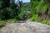 Pengendara sepeda motor melintasi jalan yang rusak di Cikadu, Kabupaten Cianjur, Jawa Barat, Sabtu (30/11/2024). Warga mengeluhkan kondisi jalan penghubung dari Rancabali, Kabupaten Bandung menuju Sindangbarang, Kabupaten Cianjur yang tak kunjung di perbaiki sejak 2007 karena berdampak pada distribusi pertanian, sembako, serta angkutan umum yang memakan waktu lama. ANTARA FOTO/Raisan Al Farisi/agr