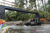 Mobil offroad melintasi Sungai Cikalumpang di Desa Wisata Padarincang, Kabupaten Serang, Banten, Minggu (1/12/2024). Pemerintah akan melanjutkan Program Pengembangan Desa Wisata yang mampu menyokong sektor pariwisata dalam memperlihatkan keindahan alam Indonesia dan membantu memberdayakan perekonomian masyarakat lokal. ANTARA FOTO/Putra M. Akbar/gp