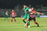 Pesepak bola Madura United FC Taufik Hidayat (kanan) berebut bola dengan pesepak bola Persebaya Surabaya Malik Risaldi (kiri) pada pertandingan BRI Liga 1 di Stadion Gelora Bangkalan, Bangkalan, Jawa Timur, Senin (2/12/2024). Persebaya Surabaya menang 2-1 atas Madura United FC. Antara Jatim/Rizal Hanafi/um