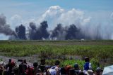 Sejumlah warga menyaksikan ledakan amunisi dari pesawat tempur Sukhoi Su-30 saat pelaksanaan Fire Power Demo dalam Latihan Angkasa Yudha 2024 di Lapangan Air Weapon Range (AWR) Pandanwangi, Lumajang, Jawa Timur, Selasa (3/12/2024). Latihan tempur yang menyimulasikan 16 misi operasi militer diikuti sedikitnya 2512 personel TNI AU dengan menggunakan 54 pesawat tempur dan lima pesawat penunjang tersebut bertujuan untuk mendemonstrasikan keterpaduan satuan-satuan TNI AU dalam mengoperasikan dan menerapkan doktrin operasi udara. Antara Jatim/Irfan Sumanjaya/um