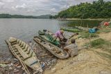 Sejumlah warga mencari ikan di sekitar alat berat penyedot sedimen (dredger) di Bendungan Waduk Pacal, Bojonegoro, Jawa Timur, Senin (2/12/2024). Upaya tersebut dilakukan pemerintah setempat guna mengatasi pendangkalan dan penyumbatan di pintu air bendungan berkapasitas 44 juta meter kubik yang dimanfaatkan warga setempat untuk irigasi pertanian, pariwisata, dan perikanan. Antara Jatim/Muhammad Mada/um