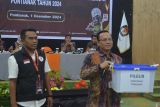 Ketua KPU Kota Pontianak David Teguh (kanan) bersama Ketua Bawaslu Kota Pontianak Ridwan (kiri) saat memperlihatkan kotak rekapitulasi suara Pilgub untuk Pontianak Tenggara pada Rapat Pleno Rekapitulasi Hasil Penghitungan Perolehan Suara Pilkada Kalbar dan Pilwako Pontianak di Pontianak, Kalimantan Barat, Minggu (1/12/2024). KPU Kota Pontianak menggelar rekapitulasi penghitungan suara Pilgub Kalimantan Barat dan Pilwalko Pontianak 2024 dari 904 Tempat Pemungutan Suara (TPS) yang tersebar di enam kecamatan di wilayah setempat. ANTARA/Kristian Jonathan