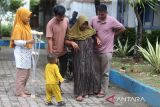 Seorang penyandang disabilitas mencoba berjalan dengan dibantu keluarganya seusai pemasangan kaki palsu di Rumoh Sejahtera , Banda Aceh, Aceh, Selasa (3/12/2024). Pemerintah Aceh memberikan bantuan kaki palsu kepada sebanyak 56 penyandang disabilitas dari sejumlah kabupaten/kota di daerah itu yang merupakan rangkaian dari kegiatan peringatan Hari Disabilitas Internasional. ANTARA FOTO/Ampelsa.