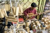 Perajin memainkan gitar dari bambu (Bambusoideae) saat pameran kerajinan Festival Sada Awi di Bandung, Jawa Barat, Rabu (4/12/2024). Data Badan Riset dan Inovasi Nasional (BRIN) tahun 2024, Indonesia menjadi rumah bagi 175 jenis bambu dari 1.439 jenis di dunia, dengan 60 spesies di antaranya endemik seperti bambu duri, bambu pagar, haur hejo, bambu kuning, bambu apus serta bambu hitam. ANTARA FOTO/Novrian Arbi/agr