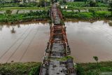 Foto udara kondisi jembatan rusak di Kertosono, Nganjuk, Jawa Timur, Selasa (3/12/2024). Jembatan peninggalan Belanda yang menjadi alternatif penghubung tiga kabupaten yakni Kabupaten Nganjuk, Kabupaten Jombang, serta Kabupaten Kediri itu kini kondisinya rusak berat dan telah ditutup total sejak tahun 2018. ANTARA Jatim/Muhammad Mada/mas.