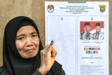 Warga menunjukkan jari bernoda tinta seusai menggunakan hak pilihnya saat pemungutan suara ulang (PSU) di TPS 001 Kelurahan Bugis, Samarinda, Kalimantan Timur, Senin (2/12/2024). KPU Kota Samarinda melakukan PSU di TPS 001 tersebut atas rekomendasi dari Bawaslu Kaltim karena adanya pemilih pindahan yang menerima surat suara tidak sesuai aturan. Antara Kaltim/M Risyal Hidayat