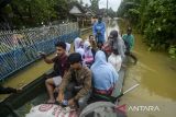 Pelajar menggunakan perahu menerobos banjir di Pagelaran, Pandeglang, Banten, Kamis (5/12/2024). Banjir luapan sungai Cilemer yang terjadi sejak Senin (2/12) setinggi 1 meter hingga 2,5 meter tersebut mengakibatkan akses jalan warga terbatas dan harus menggunakan perahu untuk beraktivitas. ANTARA FOTO/Muhammad Bagus Khoirunas/gp