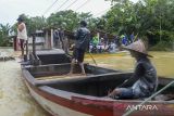 Warga berada di atas perahu bersiap menerobos banjir di Pagelaran, Pandeglang, Banten, Kamis (5/12/2024). Banjir luapan sungai Cilemer yang terjadi sejak Senin (2/12) setinggi 1 meter hingga 2,5 meter tersebut mengakibatkan akses jalan warga terbatas dan harus menggunakan perahu untuk beraktivitas. ANTARA FOTO/Muhammad Bagus Khoirunas/gp