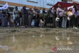 Sejumlah warga berdiri di dekat tenda pengungsian saat apel gelar pasukan dan simulasi penanganan bencana banjir di Rusunawa Margaluyu, Kota Serang, Banten, Kamis (5/12/2024). Apel dan simulasi yang diselenggarakan oleh Palang Merah Indonesia (PMI) Provinsi Banten tersebut sebagai upaya kesiapan petugas dan relawan saat menghadapi bencana banjir, mengingat sejumlah wilayah di Banten terdampak banjir sejak Senin, 2 Desember kemarin. ANTARA FOTO/Angga Budhiyanto/gp