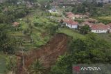 Foto udara material tanah longsor di Desa Sukahening, Kabupaten Tasikmalaya, Jawa Barat, Kamis (5/12/2024). Curah hujan yang tinggi di Kabupaten Tasikmalaya mengakibatkan lahan pertanian dan kandang ternak milik warga tertimbun tanah longsor dan tiga rumah terancam longsor susulan. ANTARA FOTO/Adeng Bustomi/agr