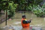 Anggota BPBD Kabupaten Pandeglang dan Babinsa melihat kondisi banjir di Desa Idaman, Pandeglang, Banten, Kamis (5/12/2024). Sebanyak 430 rumah yang berada di empat kampung di Desa Idaman tersebut terisolir akibat banjir dari luapan sungai Cilemer setinggi 1-2,5 meter sejak Senin (2/12), namun warga tetap memilih bertahan di rumahnya masing-masing. ANTARA FOTO/Muhammad Bagus Khoirunas/gp