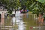 Warga menggunakan perahu menerobos banjir di Pagelaran, Pandeglang, Banten, Kamis (5/12/2024). Pemerintah Kabupaten Pandeglang menetapkan status siaga darurat bencana banjir usai 18 kecamatan di Pandeglang terendam banjir dengan jumlah korban mencapai 15 ribu jiwa atau 4.432 kepala keluarga (kk). ANTARA FOTO/Muhammad Bagus Khoirunas/gp