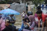 Warga berjalan menerobos banjir di Pagelaran, Pandeglang, Banten, Kamis (5/12/2024). Pemerintah Kabupaten Pandeglang menetapkan status siaga darurat bencana banjir usai 18 kecamatan di Pandeglang terendam banjir dengan jumlah korban mencapai 15 ribu jiwa atau 4.432 kepala keluarga (kk). ANTARA FOTO/Muhammad Bagus Khoirunas/gp