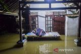 Warga tidur di depan teras rumahnya saat banjir di Pagelaran, Pandeglang, Banten, Kamis (5/12/2024). Banjir akibat curah hujan tinggi yang menyebabkan meluapnya sungai Cilemer tersebut terpantau berangsur surut, namun sejumlah titik permukiman masih ada yang terendam hingga sekitar 1,5 meter. ANTARA FOTO/Muhammad Bagus Khoirunas/gp