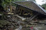 Warga melihat rumah yang rusak terdampak bencana pergerakan tanah di Kadupandak, Kabupaten Cianjur, Jawa Barat, Jumat (6/12/2024). Badan Nasional Penanggulangan Bencana (BNPB) menyatakan dampak bencana geologi pergerakan tanah dari dua kecamatan di Kabupaten Cianjur tersebut mengakibatkan sebanyak 85 rumah rusak berat serta 105 unit rumah berpotensi terancam sejak peristiwa yang terjadi pada Jumat (22/11) lalu. ANTARA FOTO/Novrian Arbi/agr