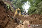 Petugas Dinas Binamarga Provinsi Jawa Barat mengoperasikan alat berat untuk membersihkan jalan utama yang dipenuhi lumpur akibat tanah longsor di Sukanagara, Kabupaten Cianjur, Jawa Barat, Jumat (6/12/2024). Akses jalan utama penghubung Kecamatan Sukanagara dengan Kecamatan Kadupandak, Kabupaten Cianjur tersebut mulai bisa dilewati kendaraan yang sebelumnya sempat terputus selama tiga hari akibat tertimbun longsor. ANTARA FOTO/Novrian Arbi/agr