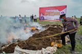 Petugas Kepolisian Polres Lumajang membakar barang bukti narkotika jenis ganja saat pemusnahan barang bukti di Lapangan Air Weapon Range (AWR) Pandanwangi, Lumajang, Jawa Timur, Jumat (6/12/2024). Polres Lumajang memusnahkan barang bukti narkotika jenis ganja sejumlah 47.169 batang pohon hidup, 52 batang pohon kering, dan 9,950 gram daun kering hasil penindakan temuan ladang ganja di kawasan TNBTS yang melibatkan 14 tersangka. ANTARA Jatim/Irfan Sumanjaya/mas.