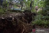 Warga melihat kondisi tanah yang terbelah terdampak pergerakan tanah di Kadupandak, Kabupaten Cianjur, Jawa Barat, Jumat (6/12/2024). Pemerintah Kabupaten Cianjur memperpanjang status Tanggap Darurat Bencana (TDB) pergerakan tanah di dua kecamatan yakni Kadupandak dan Takokak selama dua pekan ke depan seiring curah hujan yang masih tinggi dan masih meluasnya tanah bergerak di lokasi tersebut. ANTARA FOTO/Novrian Arbi/agr