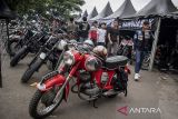 Pengunjung melihat motor klasik saat Classic Bike Race (CBR) 2024 Sirkuit Brigif Cimahi, Kota Cimahi, Jawa Barat, Sabtu (7/12/2024). Balapan motor klasik yang digelar oleh Bikers Brotherhood MC (BBMC) Indonesia tersebut diikuti oleh ratusan pembalap dari berbagai daerah dengan melombakan 24 kelas yang bertujuan untuk menyalurkan minat dan bakat sekaligus ajang silaturahim antarkomunitas motor klasik. ANTARA FOTO/Abdan Syakura/agr