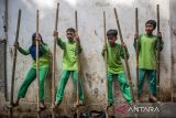 Pelajar bermain permainan tradisional egrang saat Festival Permainan Tradisional di Kampung Adat Cirendeu, Kota Cimahi, Jawa Barat, Sabtu (7/12/2024). Festival yang diisi dengan berbagai permainan tradisional seperti egrang, bedil jepret, bakiak balok, bedil peletok dan perepet jengkol tersebut digelar untuk melestarikan permainan tradisional, mengasah ketangkasan serta meningkatkan interaksi pergaulan antar anak guna mengurangi penggunaan gawai yang populer dikalangan anak-anak. ANTARA FOTO/Abdan Syakura/agr